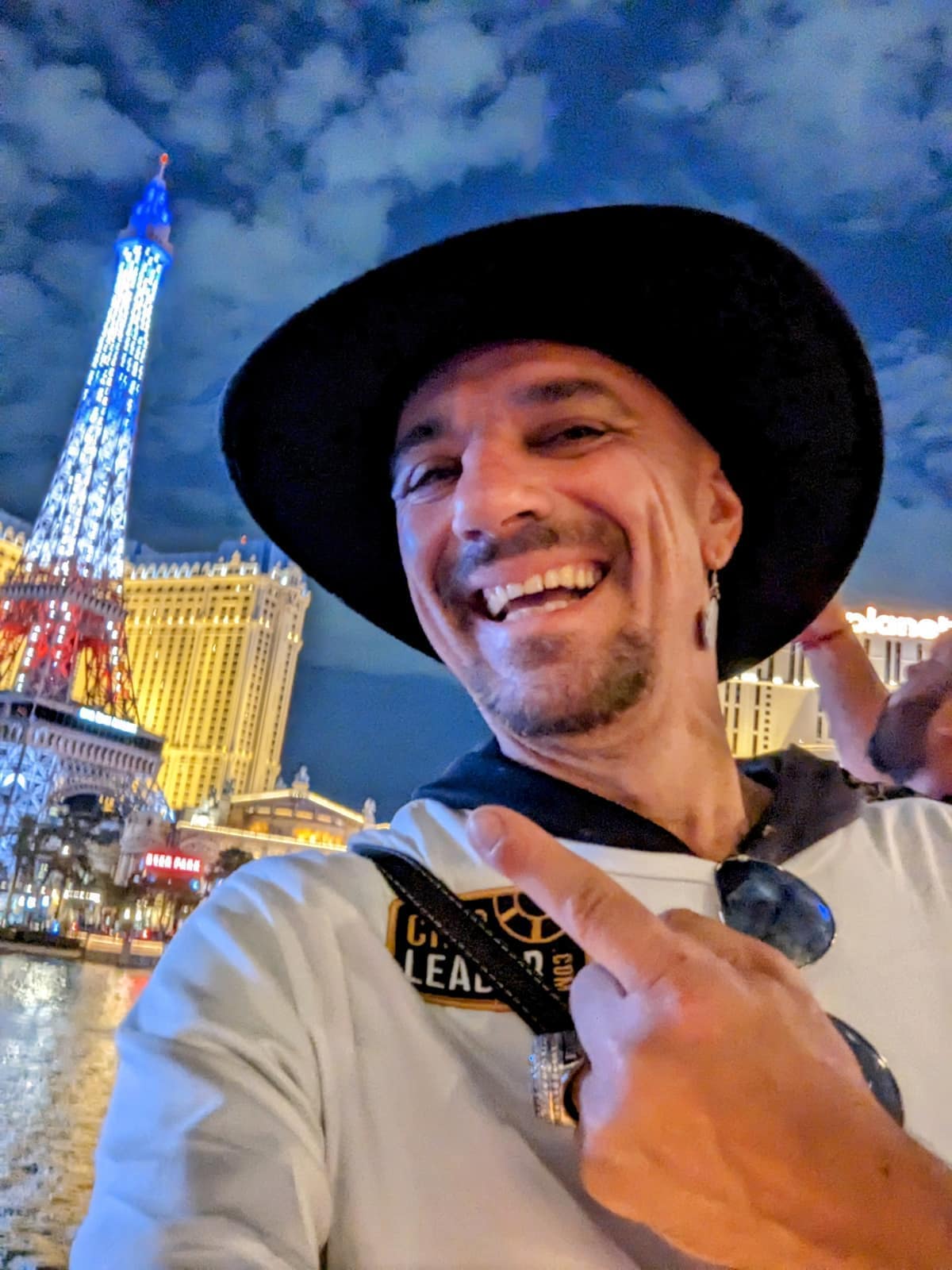 Joey smiling in front of the Paris Las Vegas Eiffel Tower at night